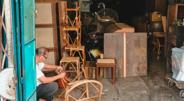 A craftsman repairing a rattan chair (stock photo)
