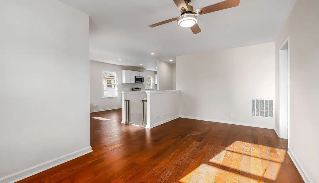 An empty apartment living room with wood floors