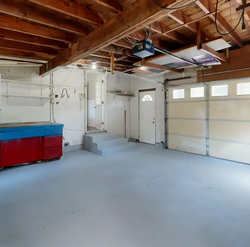 An empty, swept garage with a bare concrete floor