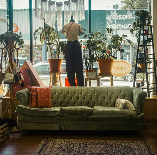 A sofa by the window of a secondhand shop